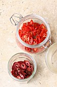 Sun-dried cherry tomatoes and strawberries in jars