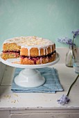Almond sponge cake with cherry jam on a cake stand