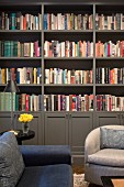 Sofa and armchairs in front of grey bookcase