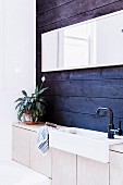 Row of vanities with wooden base cabinets against blue wall paneling
