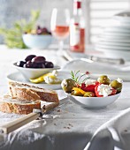 Various types of antipasti with bread and olives on a laid table