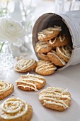 Cookies decorated with white chocolate in a storage tin