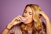 Den Gefühlshunger achtsam wahrnehmen: Frustrierte Frau isst Macaron