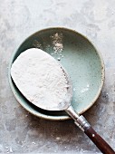 A tablespoonful of flour in a ceramic bowl (seen from above)