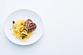 Grilled pork medallions with courgette pasta and lemon and caper butter