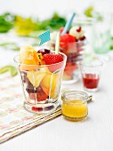 Mixed fruit salad in dessert glasses on a table outside