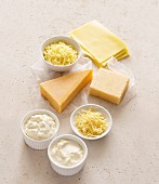 Verschiedene Käsesorten am Stück, gerieben und cremig
