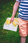 A boy carrying lemonade glasses on a tray