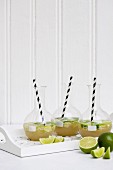 Lemonade with limes in carafes with straws