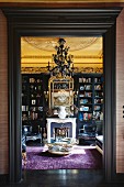 Library with open fire and gilt-framed mirror in historical interior