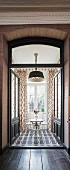 Silver bistro table and two chairs in front of French windows