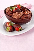 A chocolate egg filled with chocolate cream and chocolate-glazed strawberries