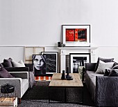Sofa set in shades of gray and coffee table with rustic table top, white fireplace cladding and framed photo art