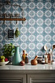 Kitchenette in front of blue and white pattern wallpaper
