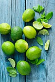 Limes and mint on a blue wooden surface