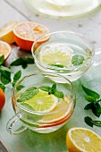 Citrus fruit tea with mint in glass cups