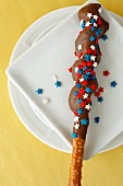 A chocolate-coated pretzel stick with red, white and blue stars for the 4th of July (USA)