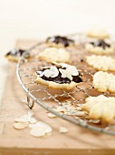 Piped biscuits with almonds and chocolate glaze on a wire rack