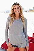 Junge blonde Frau in grauem Langarm-Hoodie