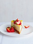 A slice of New York cheesecake with strawberry sauce and fresh strawberries