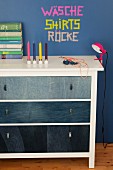 White chest of drawers with drawer fronts covered in denim
