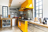 Yellow cooking area in contemporary stainless steel kitchen