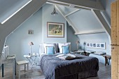 Wooden roof beams in attic bedroom in shades of blue