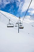 Skiers ascending on a ski lift