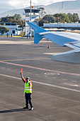 Airport worker guides jet airliner