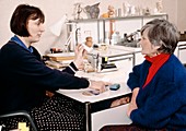 Doctor showing asthma inhalers to elderly patient