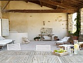 Überdachte, mediterrane Terrasse mit langem Tisch