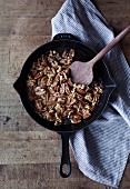 Roasted walnuts and pecan nuts and a pan (seen from above)