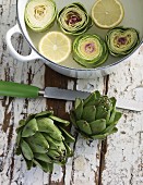 Artichokes ready to cook in a pot with a knife next to it