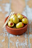 Green olives filled with peppers with toothpicks