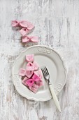 Hand-made pink bows on white plate