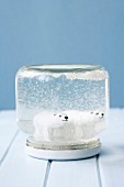 Two polar-bear figurines in snow globe hand made from screw-top jar