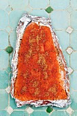 Lachs, mit Grillgewürz bestreut, auf Alufolie