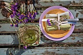 Place setting with linen napkin, cutlery and purple crocuses on wooden surface