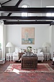 White sofa in lounge of renovated farmhouse with exposed beams