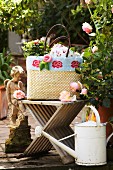Raffia shopping bag decorated with knitted trim and knitted roses on garden terrace with vintage accessories