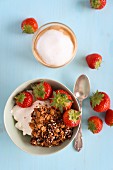 Muesli with strawberries and a cappuccino for breakfast