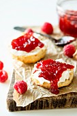 A scone with cream and raspberry jam