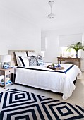 Bright bedroom with double bed and blue and white carpet