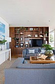 Elegant living area with shelves and cozy blue-gray upholstered furniture