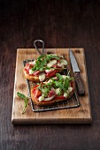 Bruschetta topped with Parma ham, mozzarella, tomatoes, olives and rocket
