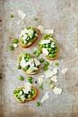 Crostini topped with fresh peas and Parmesan cheese
