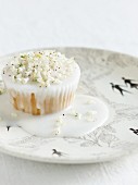 A cupcake with white icing and flowers