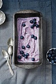 Blueberry ice cream in a loaf tin with fresh blueberries