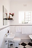 Open lattice window and black and white tiles in renovated bathroom of period apartment