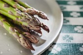 Fresh green asparagus on plate (close-up)